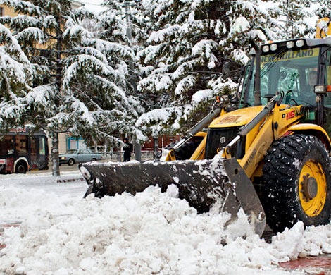 В Южно-Сахалинске экскаватор вместе со снегом снес с обочины внедорожник