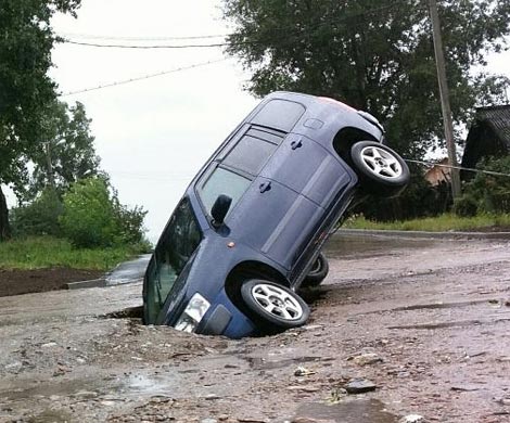 Машина провалилась под размытый дождями асфальт в Иркутске